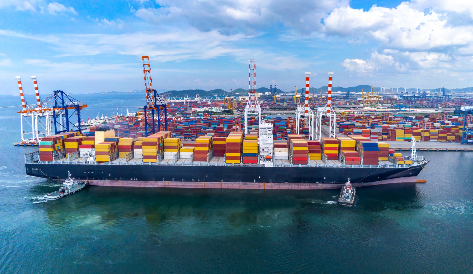 Container ship and port cranes, illustrative stock photograph